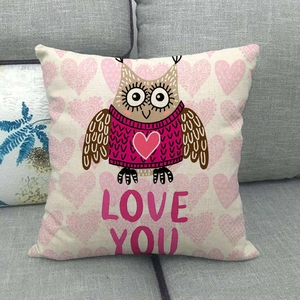 Cojín decorativo de lino con búho y texto Love You sobre un sofá gris neutro