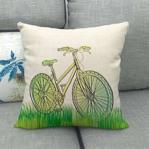 Linen decorative pillow cover with fresh green bicycle print on a grey fabric sofa