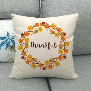 Detail of thankful letter print on linen pillowcase with autumn maple leaf wreath decoration