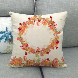 Detail of linen pumpkin wreath pillowcase on a grey fabric sofa with clear fabric texture