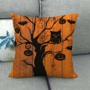 Halloween pillow cover with orange wood grain, black owls and bats on grey sofa