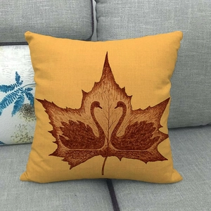 Detailed texture of linen autumn maple leaf pillow cover on a grey fabric sofa