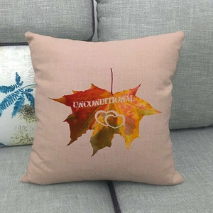 Detail view of linen pillow cover featuring painted autumn maple leaves and heart text