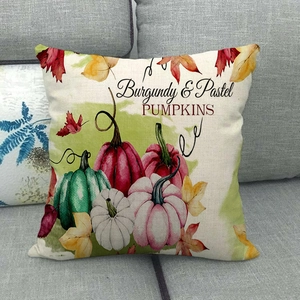Linen fall pillow cover with burgundy and pastel pumpkins design on gray sofa