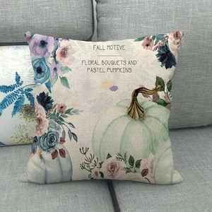 Close-up of linen cushion cover featuring pastel pumpkins and floral fall motives