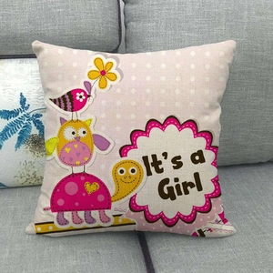 Detail of linen pillowcase with 'It's a Girl' text and owl print on a grey sofa