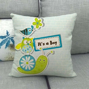 Close-up of linen cushion cover featuring cartoon owl and It's a Boy text for nursery decor