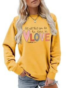 Detail of love-themed graphic print on ginger yellow long sleeve crewneck sweatshirt
