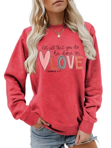 Detail of red crewneck sweatshirt with Let all that you do be done in LOVE graphic print