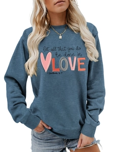 Detail showing the 'Let all that you do be done in LOVE' print on a blue cotton sweatshirt