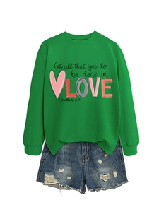 Detail of green long sleeve sweatshirt with Let All That You Do Be Done In Love print