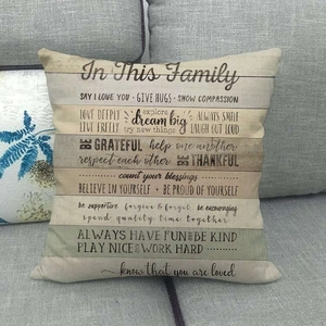 Linen decorative pillow on sofa featuring retro wood pattern and family quotes