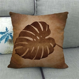 Housse de coussin en lin avec motif feuille de Monstera vintage sur canapé gris