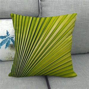Gros plan d'une housse de coussin en lin avec motif de feuille de palmier vert