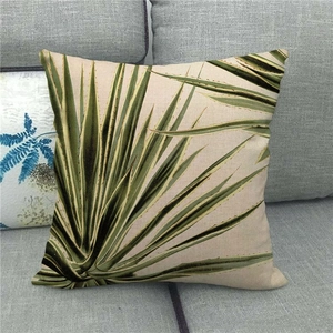 Gros plan de la housse de coussin en lin avec motif agave vert sur canapé gris
