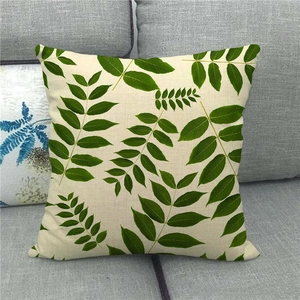 Detailed texture of linen pillowcase with green monstera leaf pattern on grey sofa