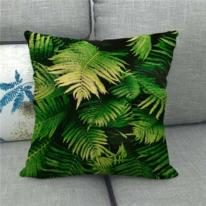 Detail of green fern leaf pattern on linen pillow cover displayed on a sofa