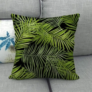 Detailed texture of tropical green palm leaf pattern on a black linen pillow cover