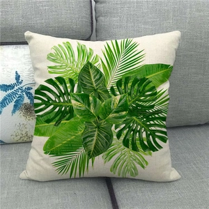 Linen monstera and palm leaf pillow cover displayed on a modern grey fabric sofa