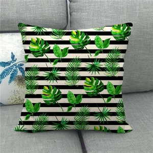 Close-up of Monstera leaf linen cushion cover with black and white stripes on sofa