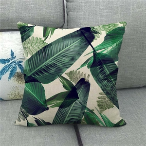 Detailed texture of linen cushion cover featuring green monstera leaf print on sofa