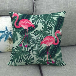 Detail of linen pillowcase featuring tropical pink flamingos and green palm leaves