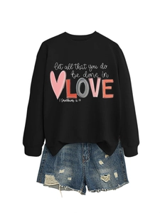 Detail of long sleeve sweatshirt with let all that you do be done in love text and denim shorts