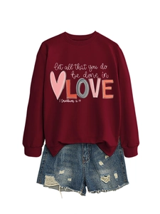 Detail of burgundy sweatshirt with let all that you do be done in love print