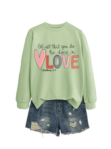 Flat lay of light green sweatshirt with 'Let all that you do be done in LOVE' text print