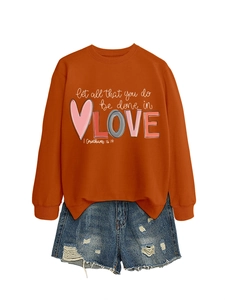 Detail of orange crewneck sweatshirt with 'LOVE' print and frayed denim shorts