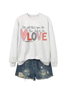 Detail of grey sweatshirt with 'let all that you do be done in LOVE' print and denim shorts
