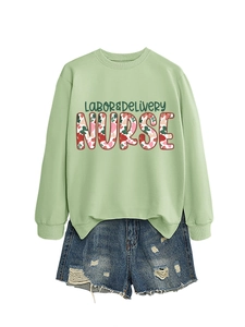Flat lay of a green Labor & Delivery Nurse sweatshirt with floral text and denim shorts