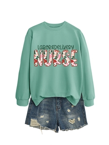 Close-up of mint green Labor & Delivery Nurse sweatshirt with floral typography and denim shorts