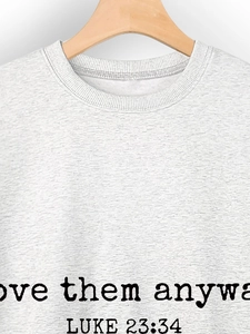 Detail of grey crewneck sweatshirt featuring Luke 23:34 scripture text print on the chest