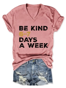 Detail view of pink V-neck t-shirt with Be Kind slogan and distressed denim shorts set