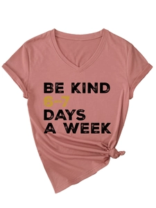 Detailed view of dust pink V-neck t-shirt with Be Kind print and side knot detail