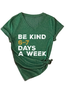 Detail of V-neck heather green T-shirt with Be Kind slogan and knotted hem styling