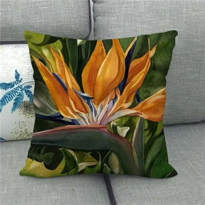 Linen cushion cover with watercolor bird of paradise flower print on a grey sofa