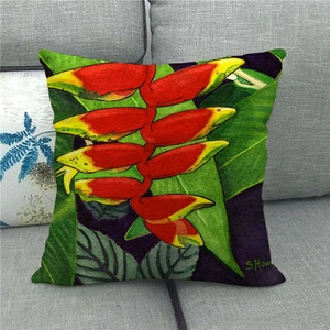 Detail showing red tropical flowers printed on linen cushion cover on a gray sofa