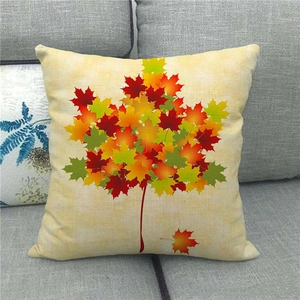 Macro shot of maple leaf pattern on square linen pillowcase against a grey sofa