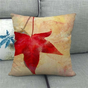Detailed close-up of maple leaf linen pillowcase on a grey sofa for fall decoration