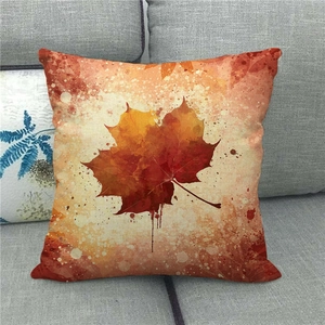 Detailed texture of autumn maple leaf linen pillow cover on a modern grey fabric sofa
