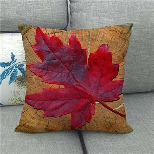 Detailed view of maple leaf print on linen pillowcase against wood grain background