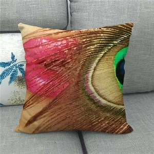 Detail eines Pfauenfeder-Prints auf einem Leinen-Kissenbezug auf einem grauen Sofa