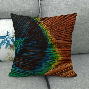 Linen cushion cover featuring colorful peacock feather pattern on a gray sofa