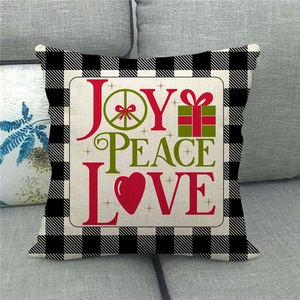 Detail of Christmas linen pillowcase featuring Joy Peace Love art on a buffalo plaid border