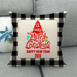Detail of Christmas buffalo plaid pillow cover with red tree print on a grey sofa