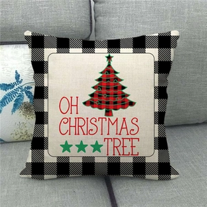 Detail of Christmas tree print on buffalo plaid linen pillowcase on a grey sofa