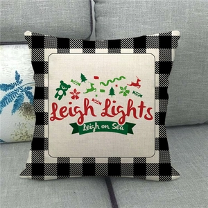 Close-up of Christmas linen pillowcase on sofa with buffalo plaid and reindeer print