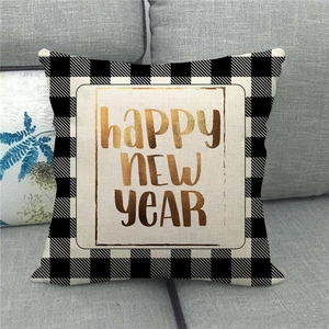 Close-up of linen New Year pillow cover with gold lettering and buffalo plaid border